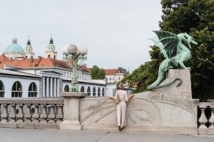 Young woman taking photo in front famous Dragon bridge in Ljubljana. Travel Explore Slovenia, Europe