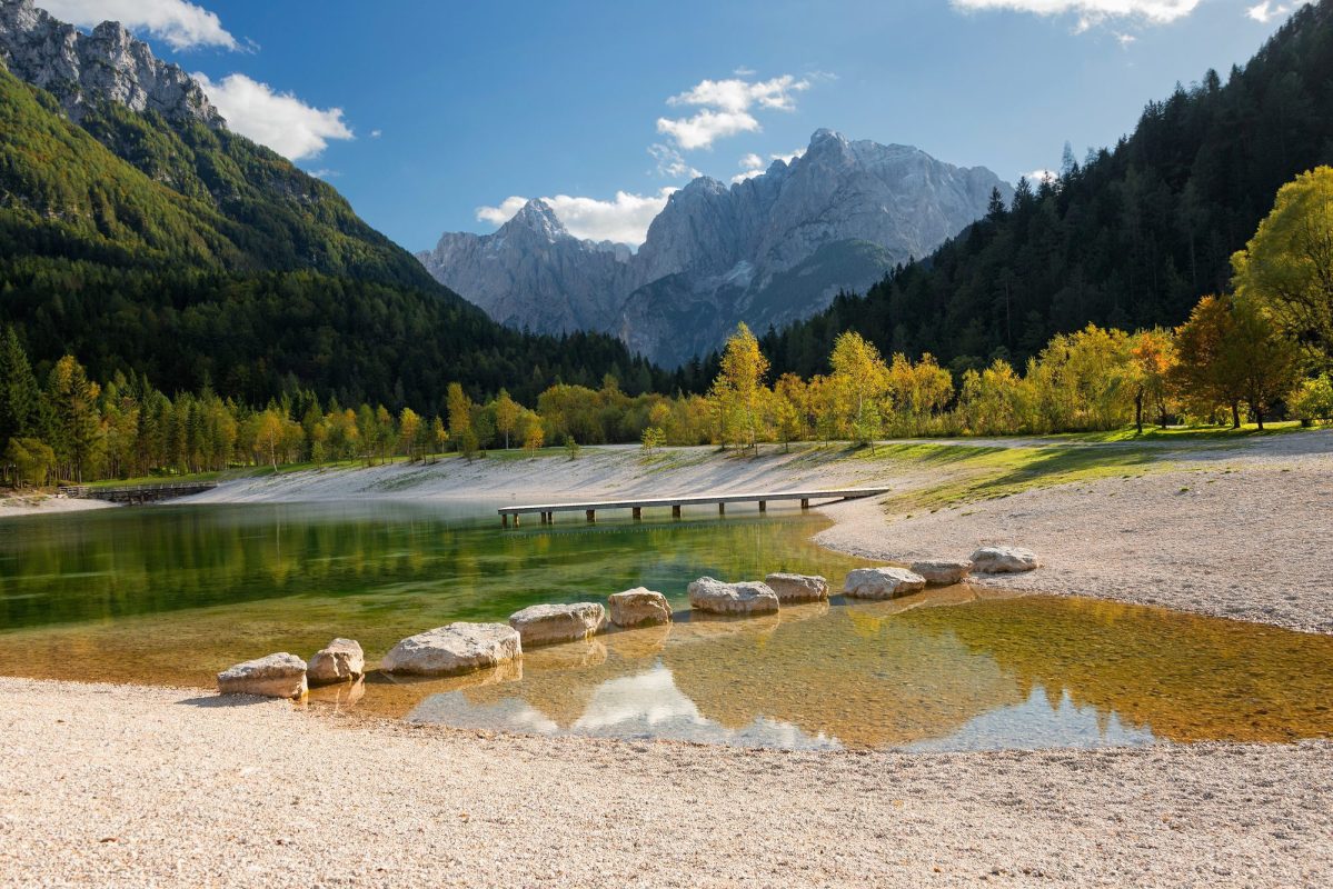 Tranquil Jasna Lake with mountain backdrop on a Kranjska Gora day tour from Ljubljana